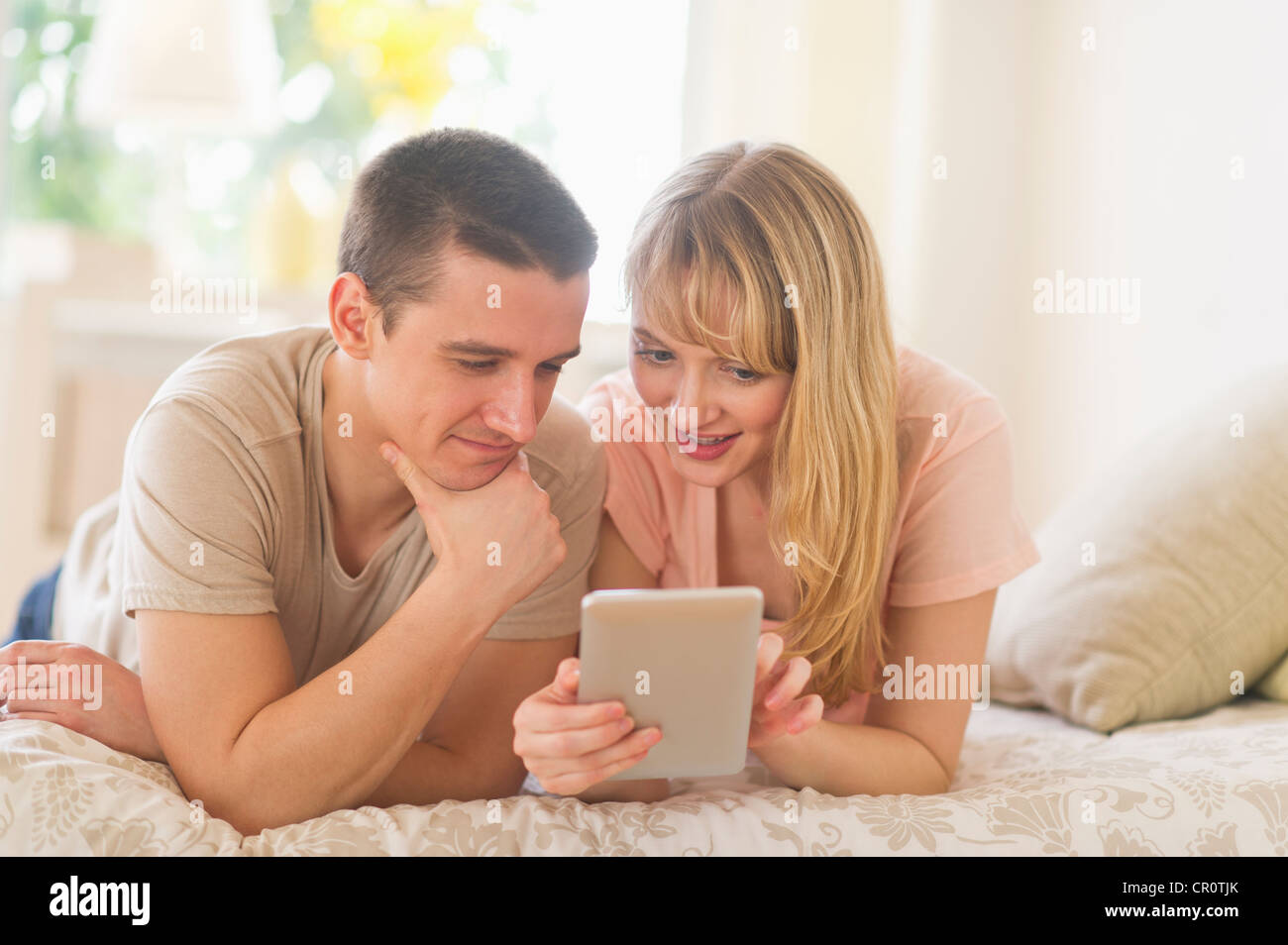 USA, New Jersey, Jersey City, Couple lying on bed and using digital tablet Banque D'Images