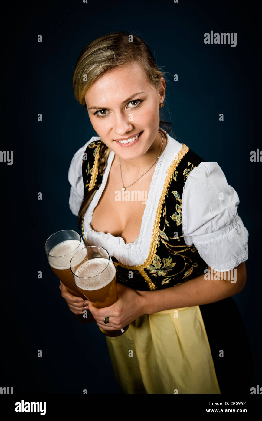 Femme vêtue de bavarois dirndl holding traditionnelle, des verres à bière Banque D'Images