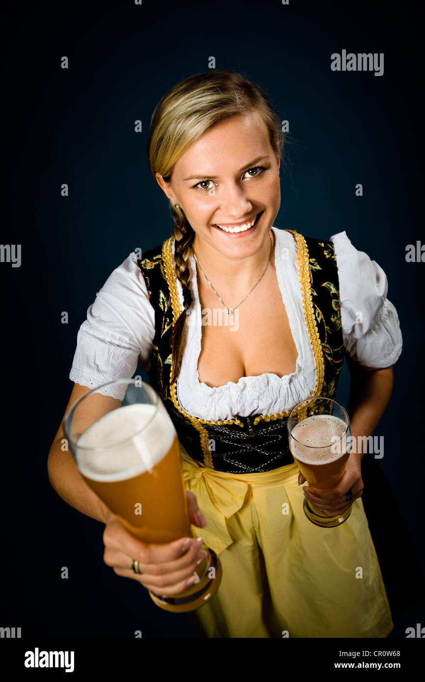 Femme vêtue de bavarois dirndl holding traditionnelle, des verres à bière Banque D'Images