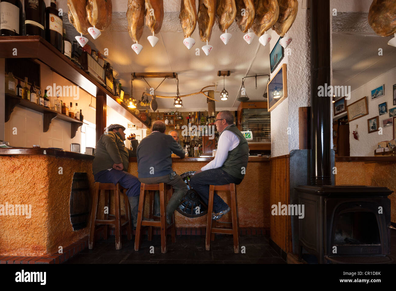 Hommes parler et manger le déjeuner au bar traditionnel restaurant Meson La Fragua à Trevélez, région de l'Alpujarra, Espagne Banque D'Images
