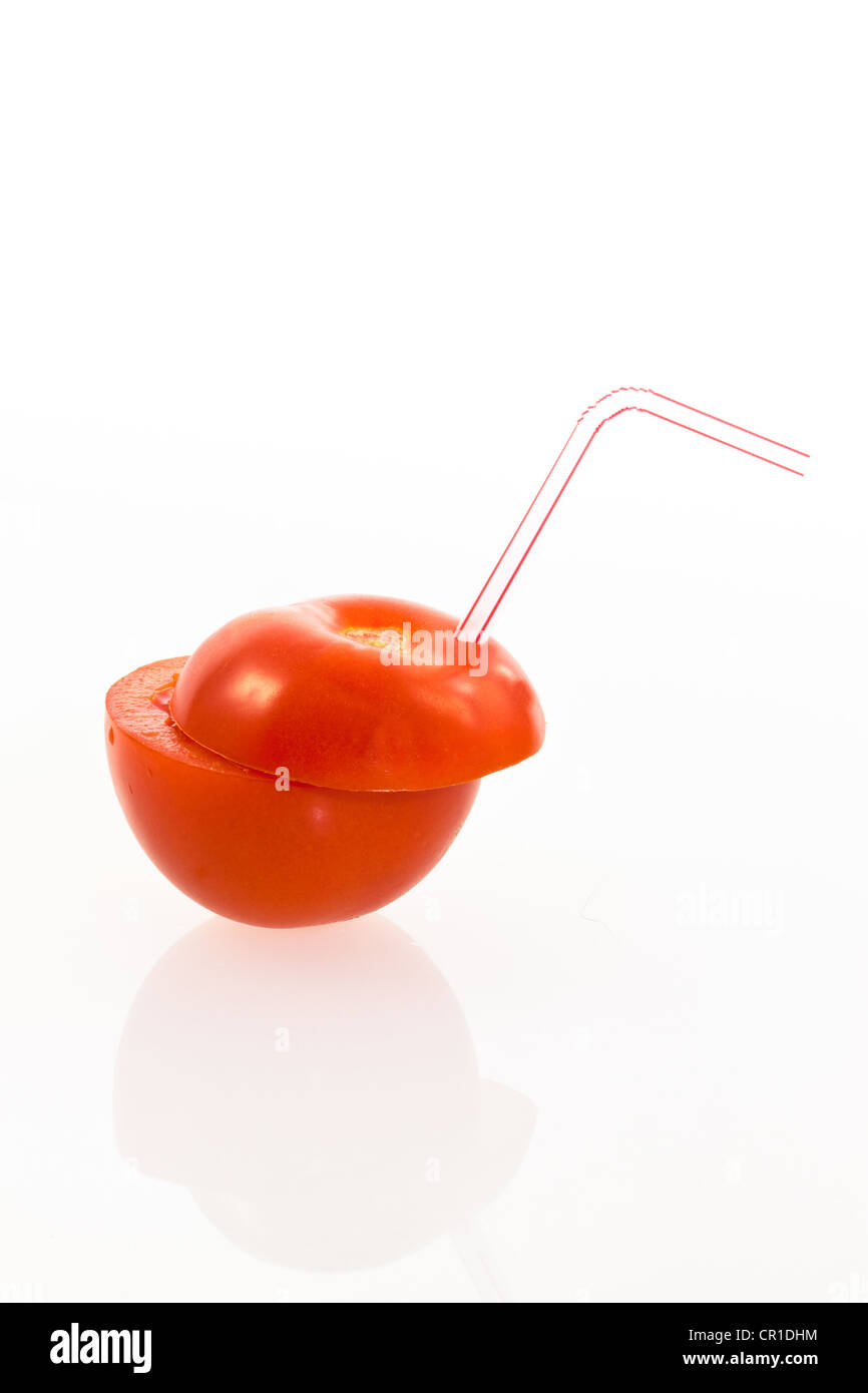 Tomates avec une paille à boire comme une boisson gazeuse Banque D'Images