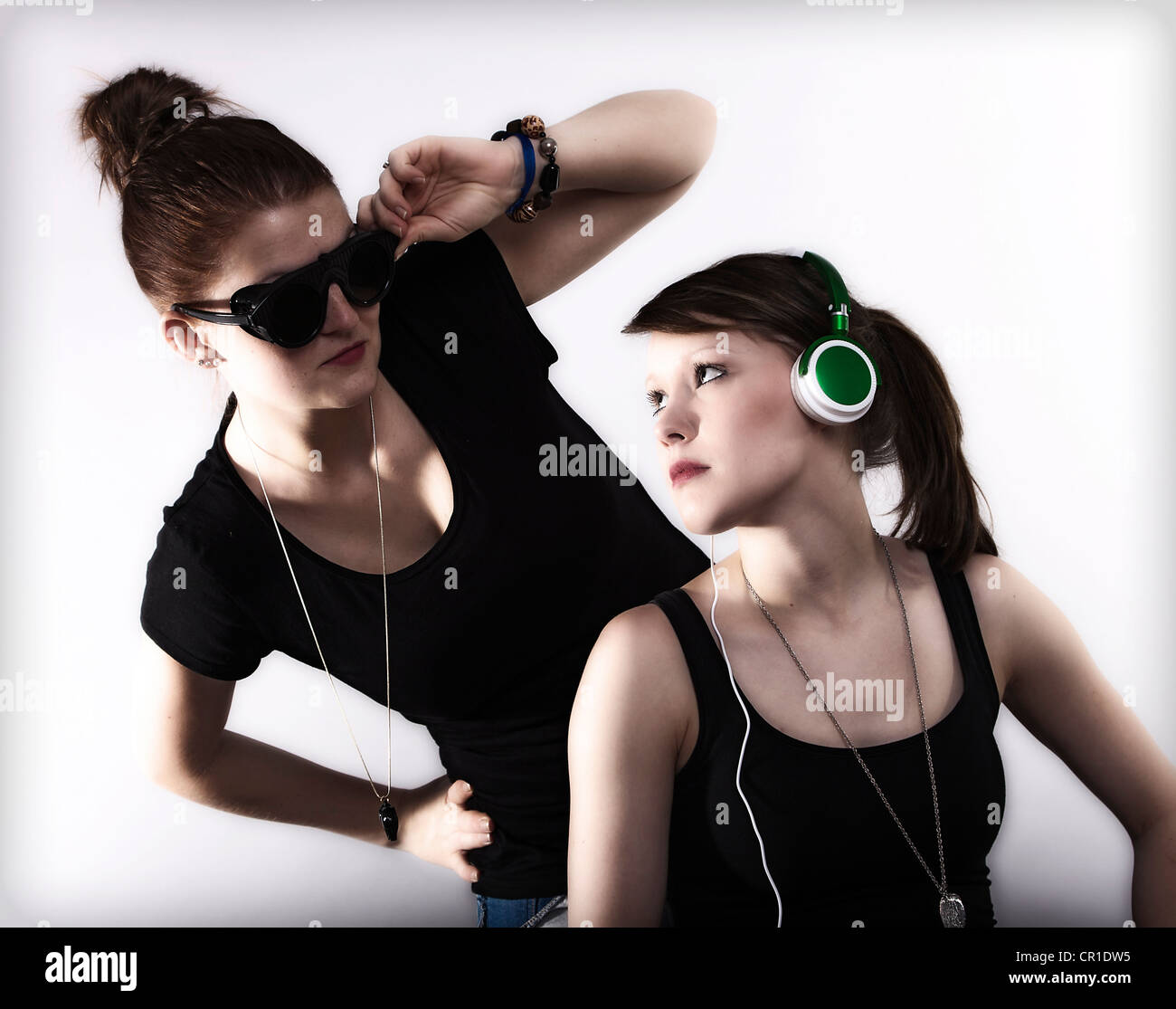 Deux jeunes femmes cool qui posent avec des lunettes et des écouteurs Banque D'Images