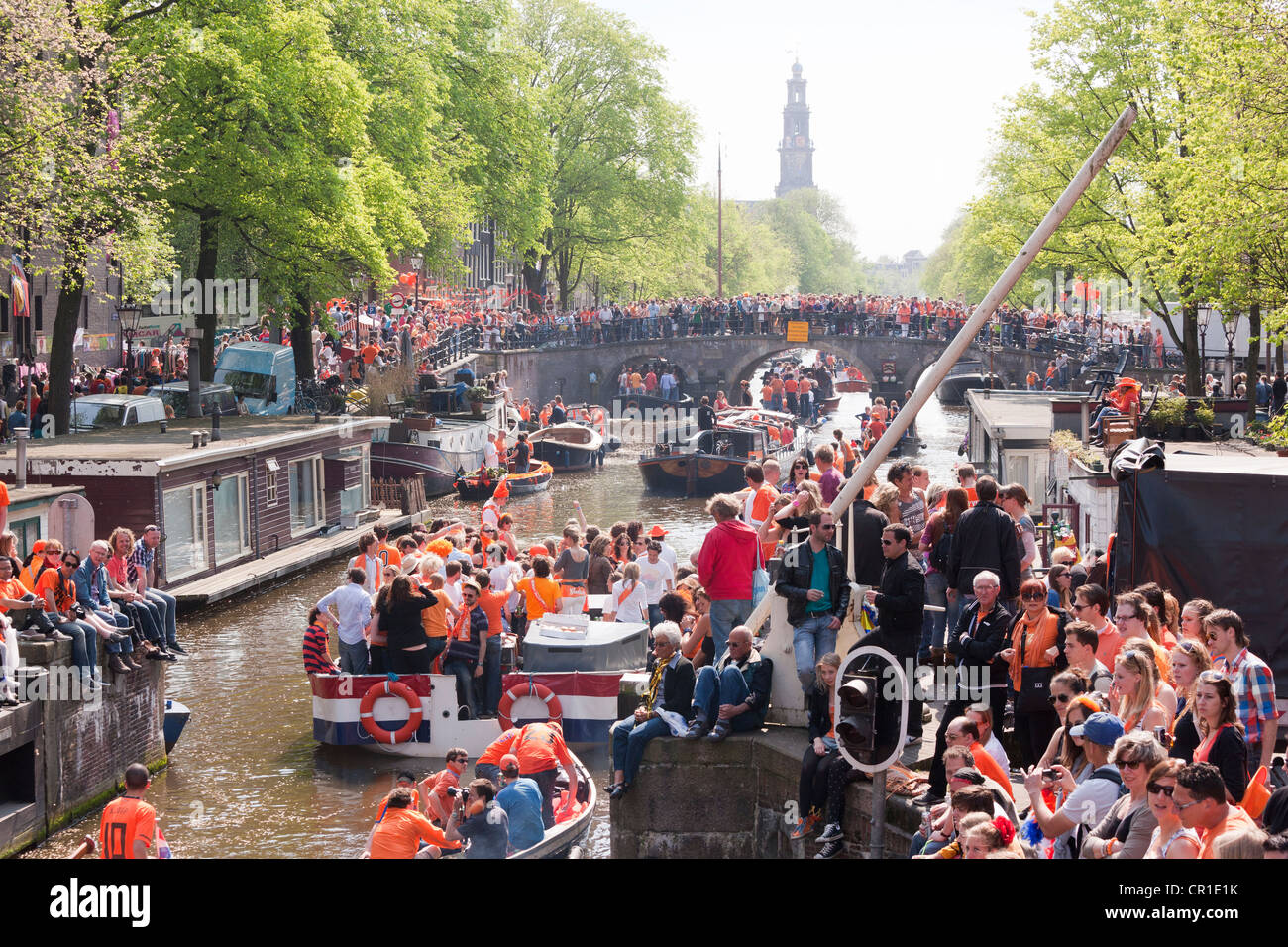 La fête du Roi Kingsday Kings Day anniversaire à Amsterdam. Défilé dans le canal Prinsengracht. Des gens portant des bateaux orange, de faire la fête. Banque D'Images