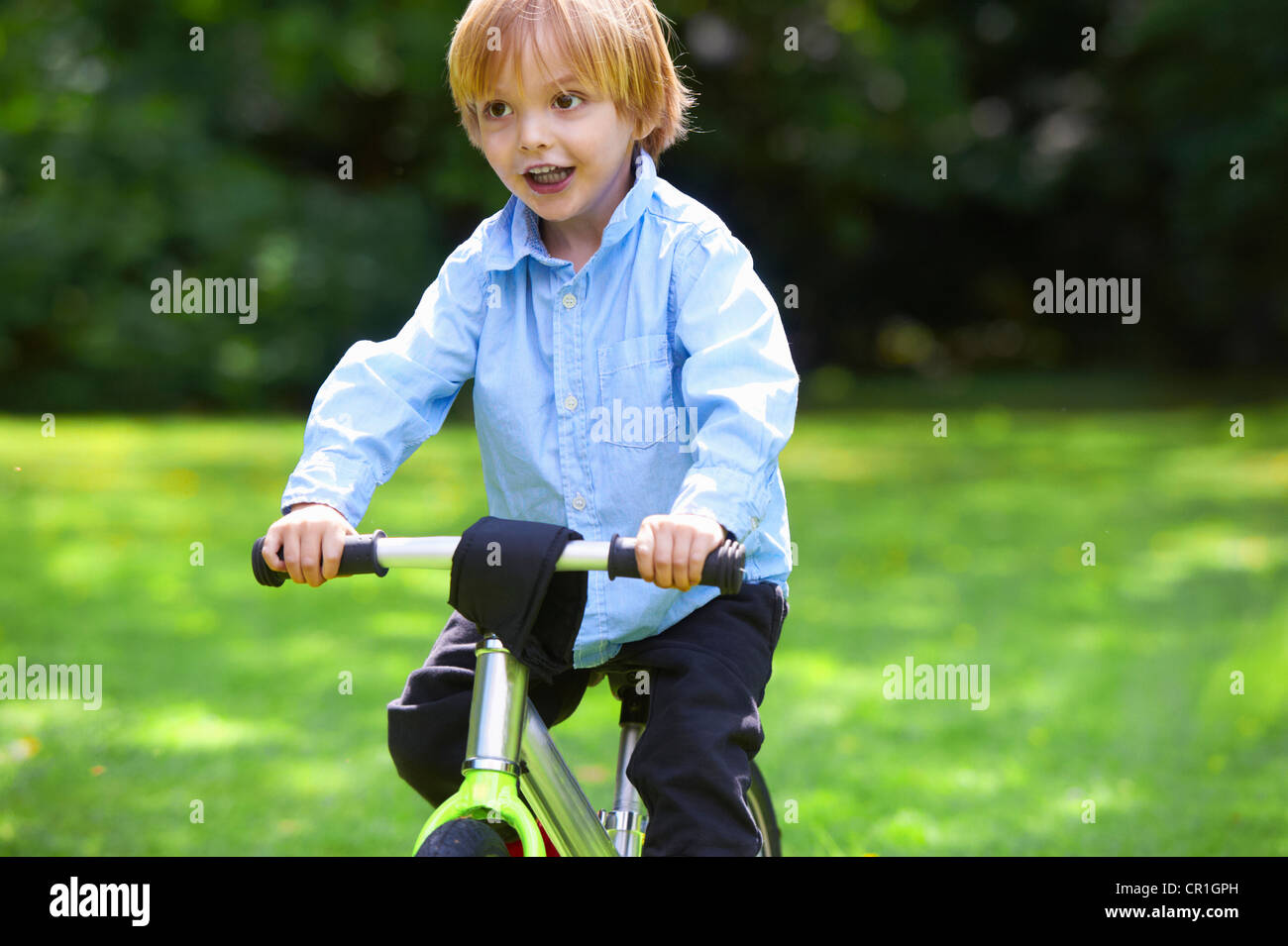 Boy riding bicycle in backyard Banque D'Images