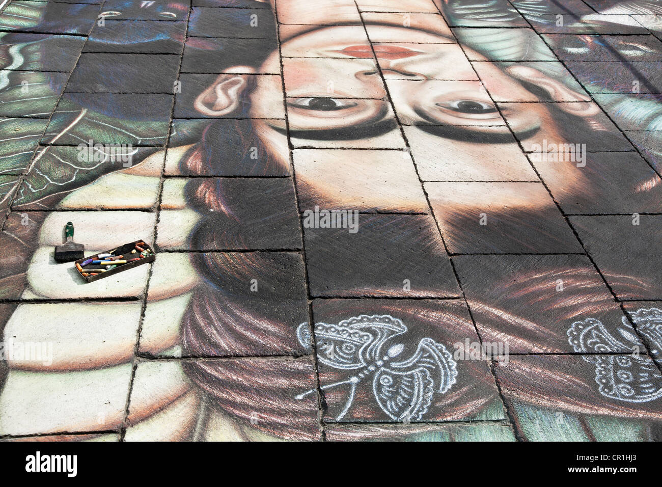 Boîte de craies se trouve sur l'article des craies de trottoir géant de dessin en hommage à Frida Kahlo Autoportrait au collier d'épines Banque D'Images