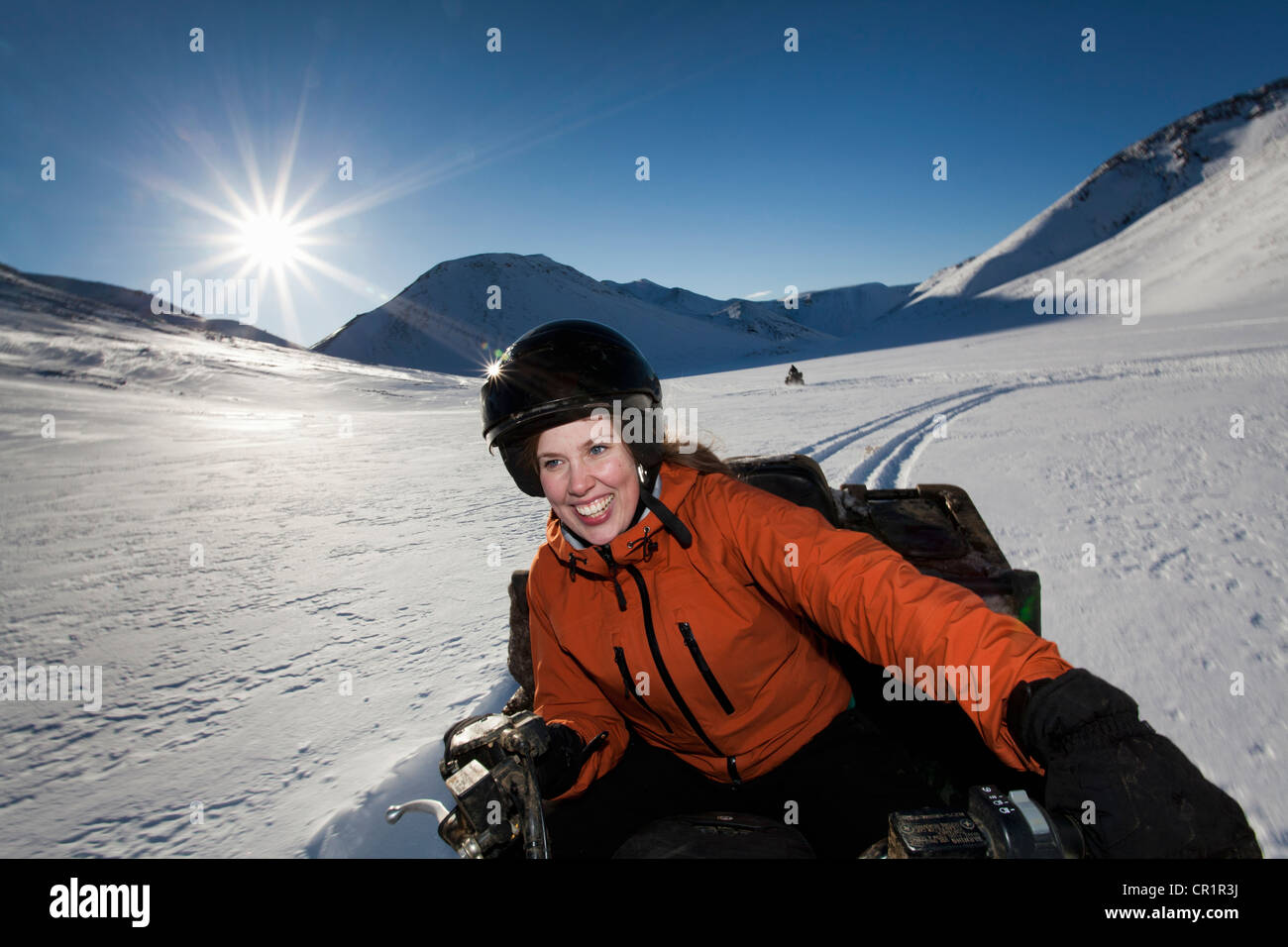 Woman driving motoneige en champ neigeux Banque D'Images