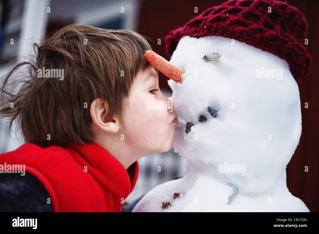 Close up of boy kissing snowman Banque D'Images