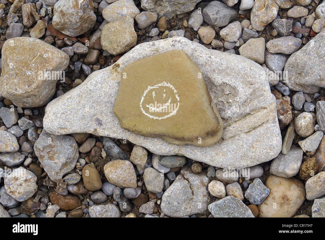 Visage sourire dessiné sur rock et placés sur une autre pierre. Banque D'Images