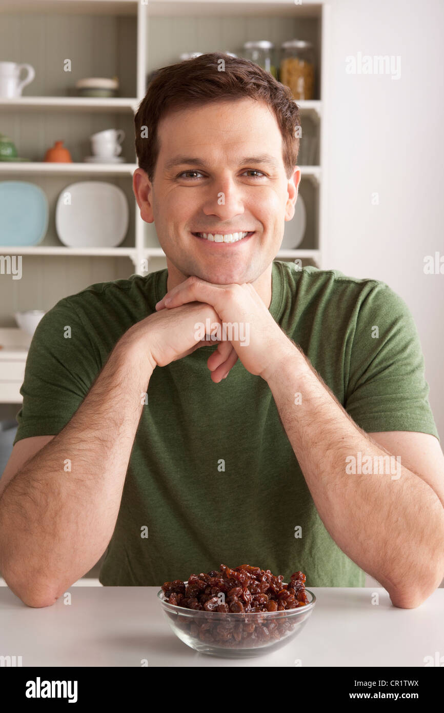 USA, Californie, Los Angeles, Portrait of mid adult man avec bol de raisins secs Banque D'Images