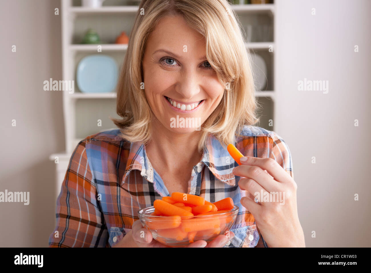 USA, Californie, Los Angeles, Portrait of mid adult woman avec bol de carottes Banque D'Images