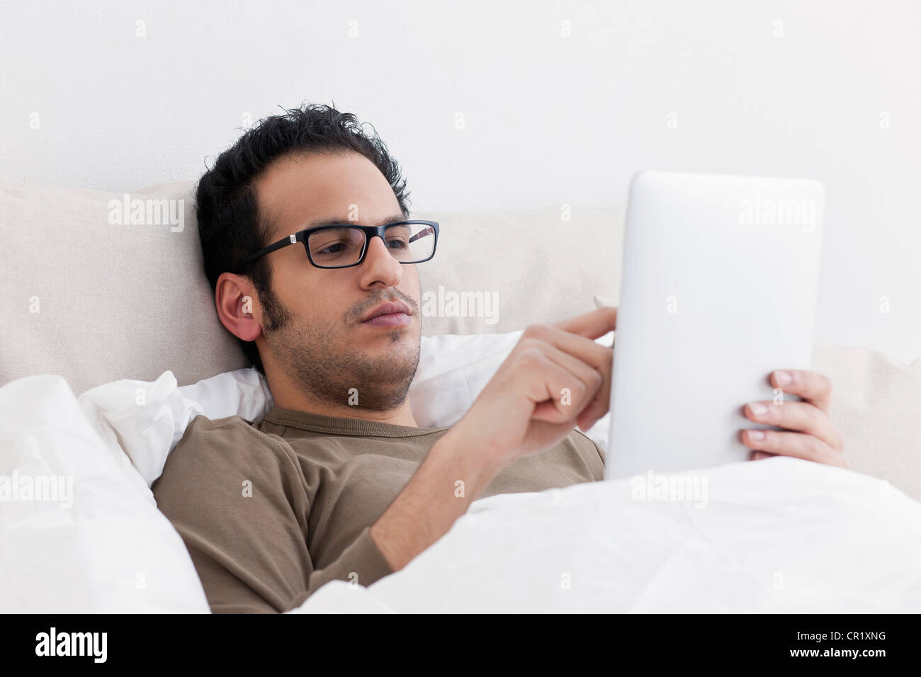 Man using tablet computer in bed Banque D'Images Man using tablet computer in bed Banque D'Images
