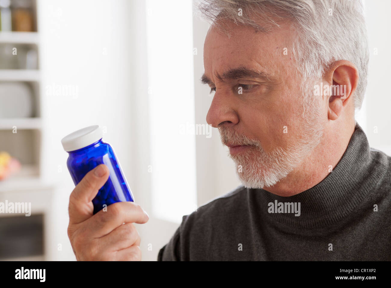 USA, Californie, Los Angeles, Senior men reading label on medicine bottle Banque D'Images