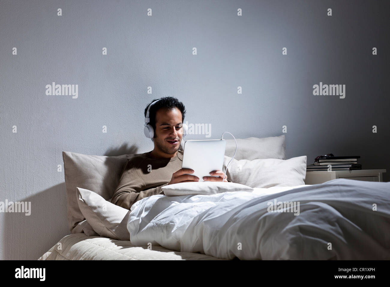 Man using tablet computer in bed Banque D'Images Man using tablet computer in bed Banque D'Images