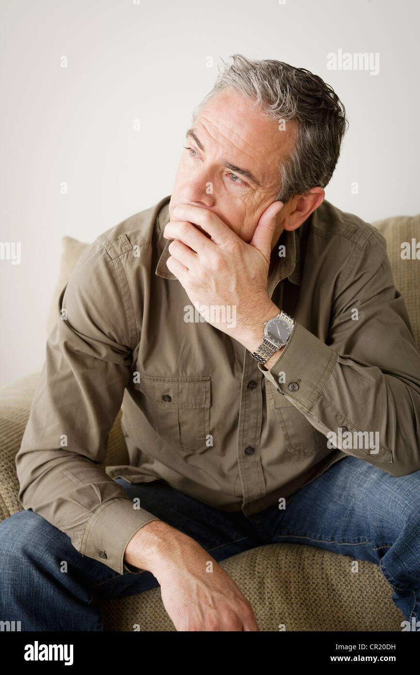 USA, Californie, Los Angeles, inquiets mature man sitting on sofa Banque D'Images