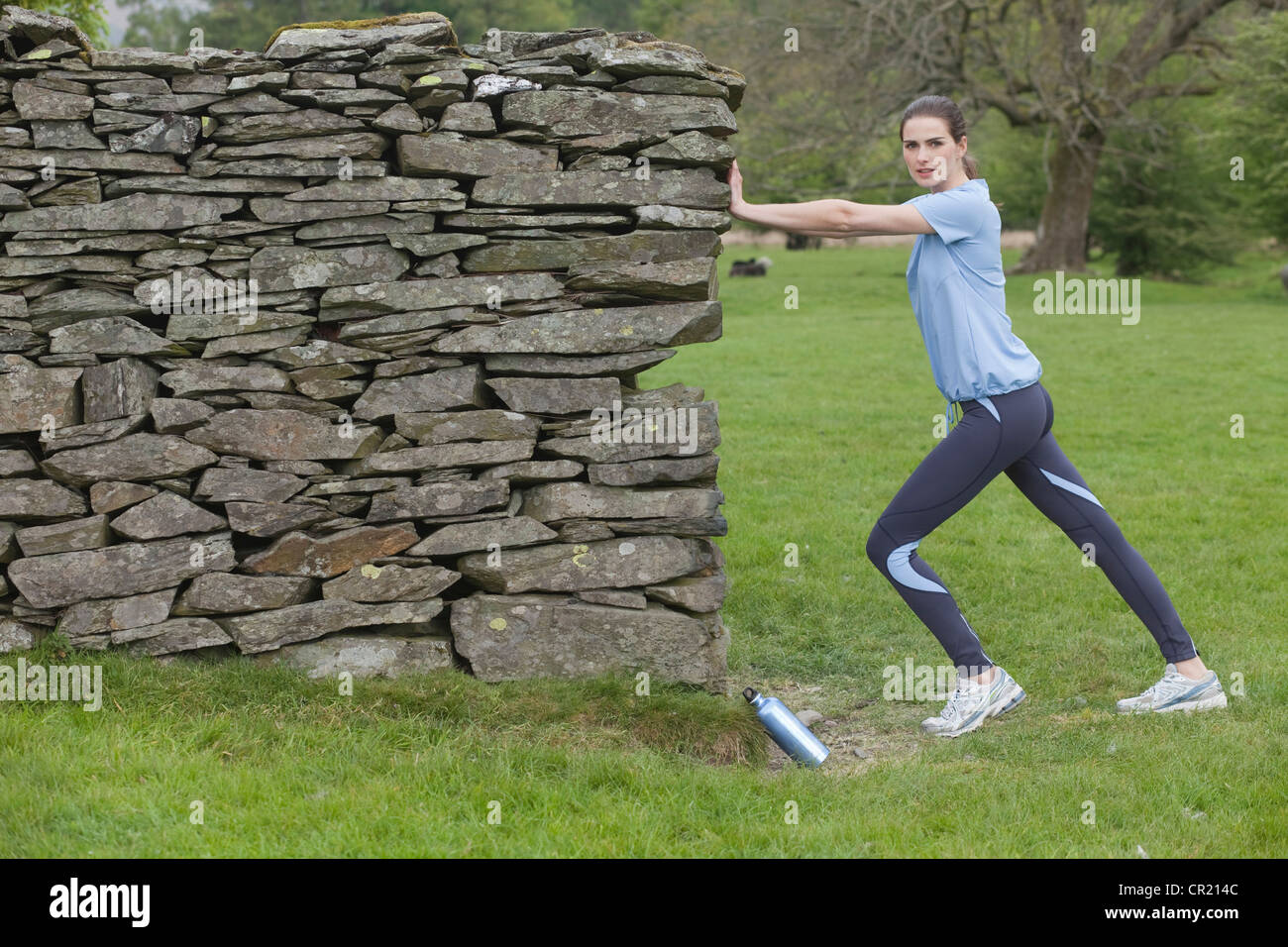 Runner stretching contre rock wall Banque D'Images