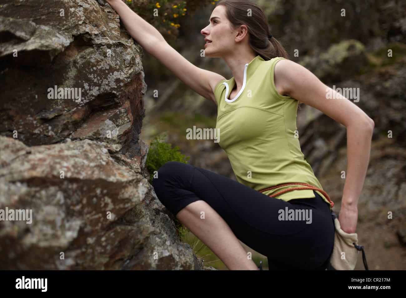 Rock climber scaling boulder Banque D'Images