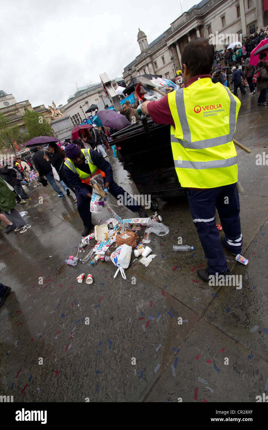 Des agents de Veolia nettoient les ordures à Trafalgar Square, à Londres, à la suite des célébrations du jubilé royal de diamant. Vêtue d'un équipement haute visibilité, l'équipe de nettoyage travaille efficacement au milieu des déchets éparpillés laissés par la foule. Les conséquences des festivités patriotiques sont évidentes : drapeaux de l'Union Jack, emballages de nourriture et confettis parsèment le sol Banque D'Images
