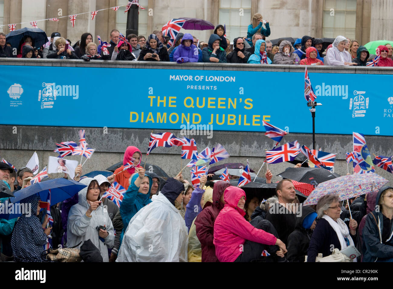 Jubilé de diamant de la Reine 2012 – les fêtards de Trafalgar Square se mettent à l’abri de la pluie alors que les célébrations se poursuivent malgré le mauvais temps. Banque D'Images