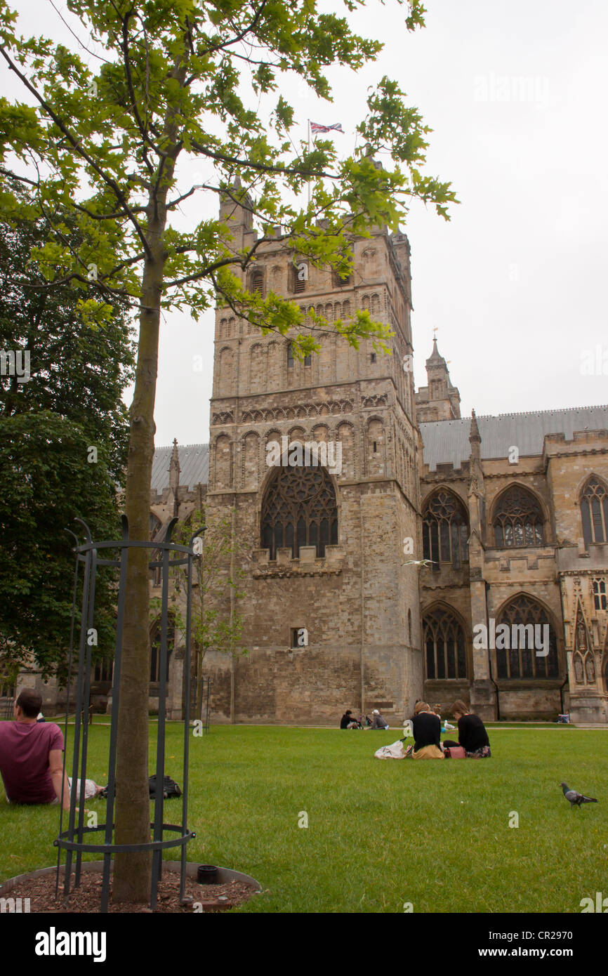 Des couples ayant repas pique-nique sur l'herbe à l'extérieur de la cathédrale d'Exeter. Banque D'Images