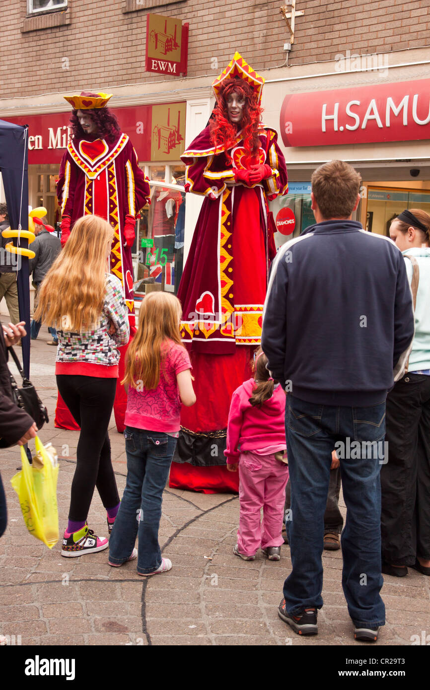 Échassiers dans 'roi et reine de coeur' des costumes, des amuseurs publics à Newton Abbot, Devon, UK. Banque D'Images