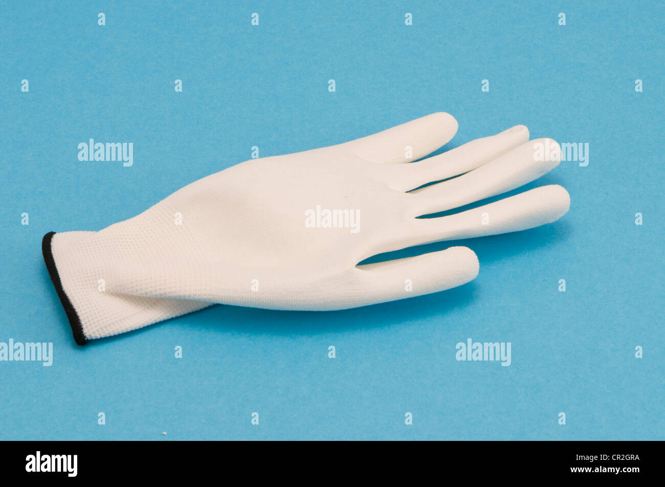 Gant de travail blanc sur fond bleu. Protéger la peau de l'objet à la main. Banque D'Images