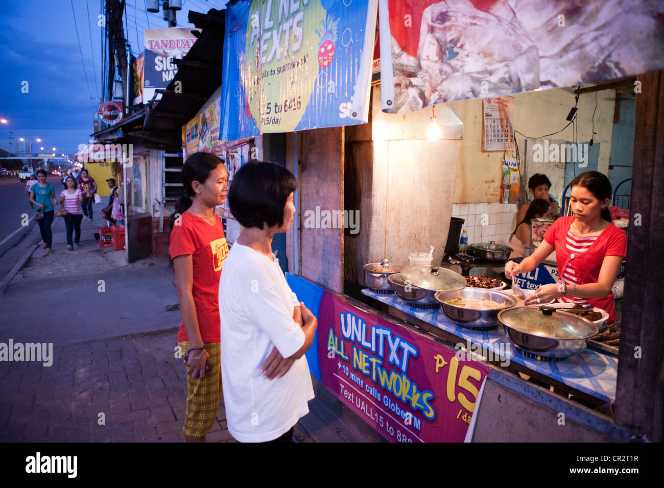 Les femmes philippines à l'achat d'aliments dans un éventaire routier eatery. Lapu-Lapu City, Metro Cebu, Mactan Island, Visayas, Philippines. Banque D'Images