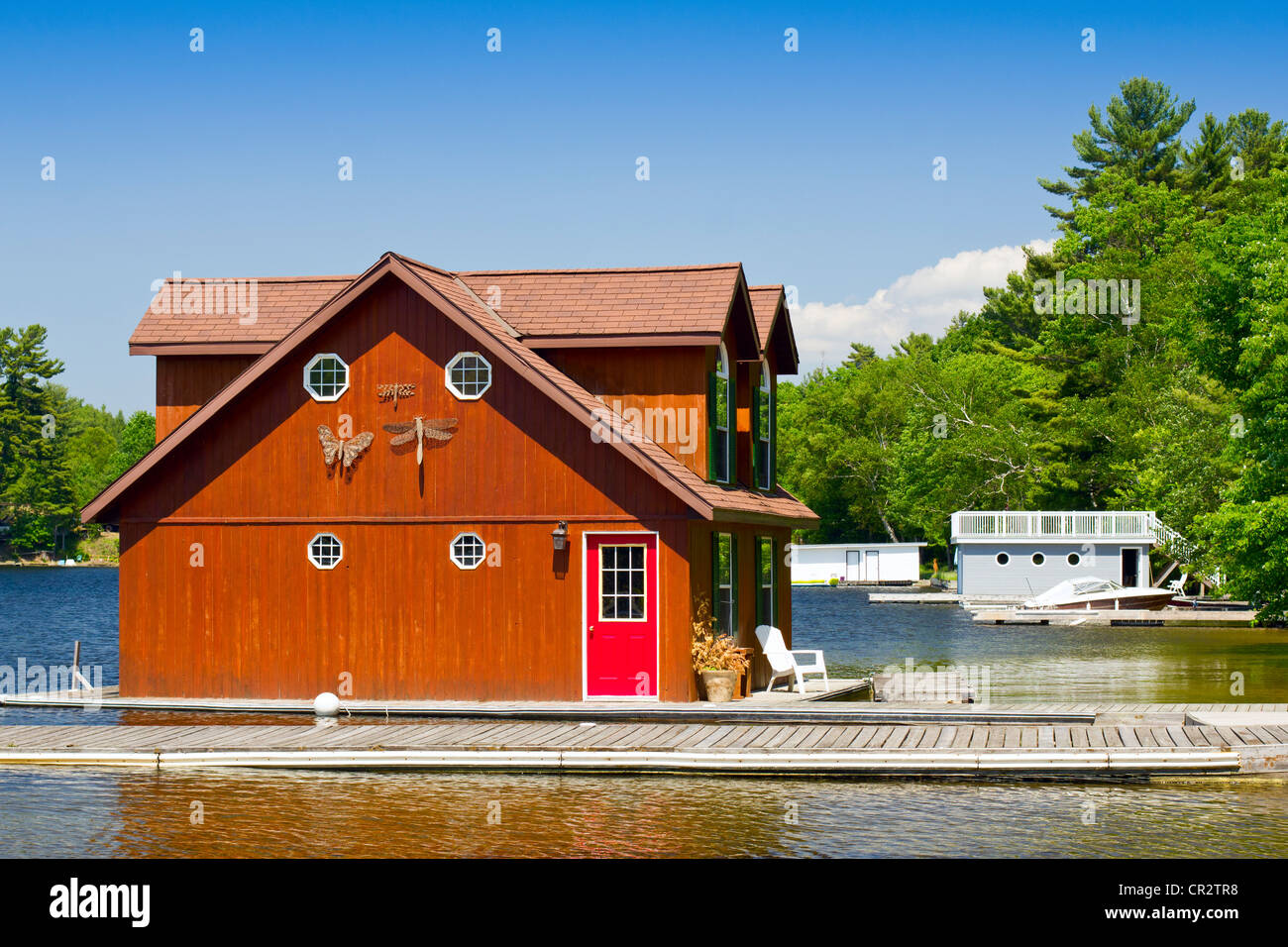 Un hangar à bateaux en bois avec porte rouge Banque D'Images
