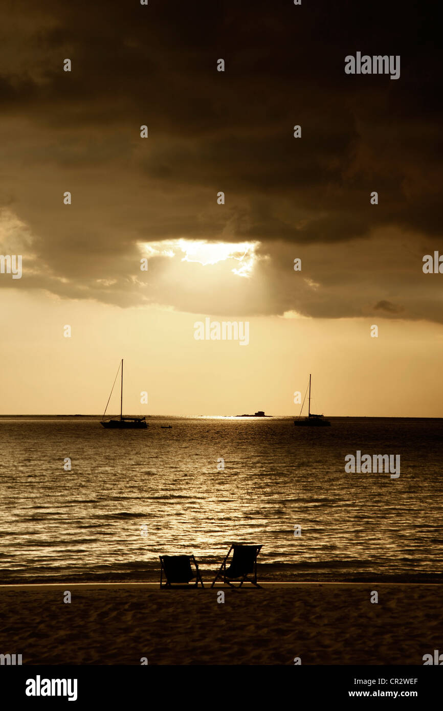 Deux fauteuils de repos sur fond de coucher du soleil Banque D'Images