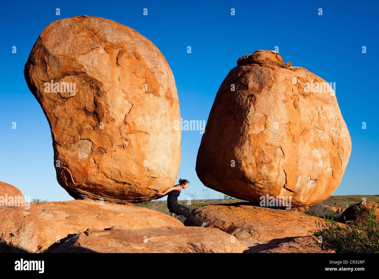 Femme tenant un rocher, Devils Marbles, Territoire du Nord, Australie Banque D'Images
