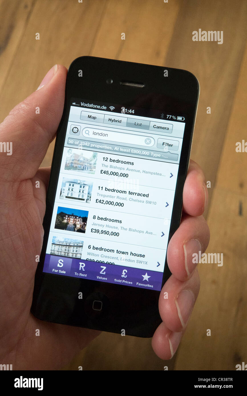 À l'aide d'un iPhone 4G téléphone intelligent pour trouver une maison à acheter sur Zoopla property trouver App Banque D'Images