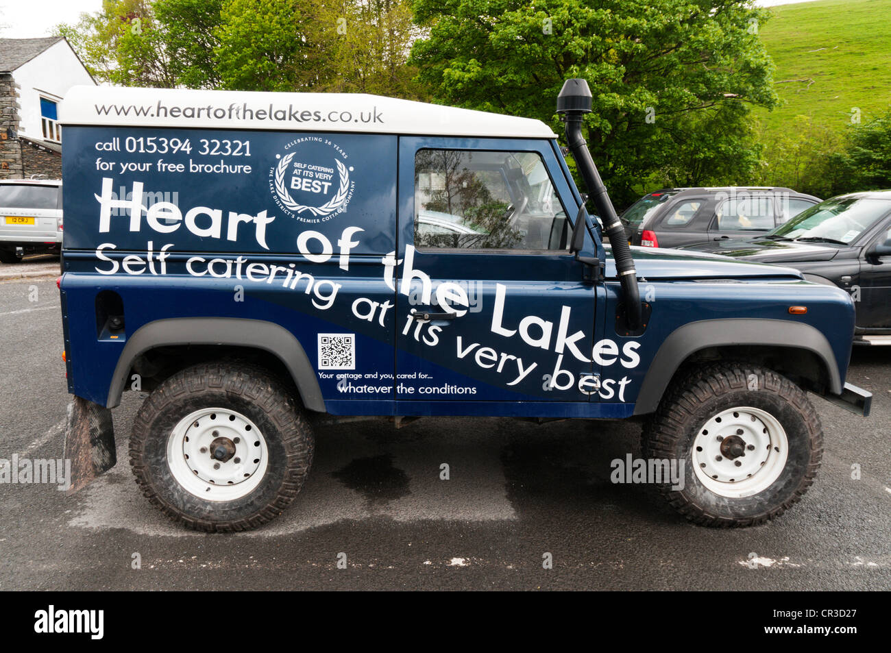 Un Land Rover Defender publicité le coeur des lacs self-catering holiday cottage company. Banque D'Images