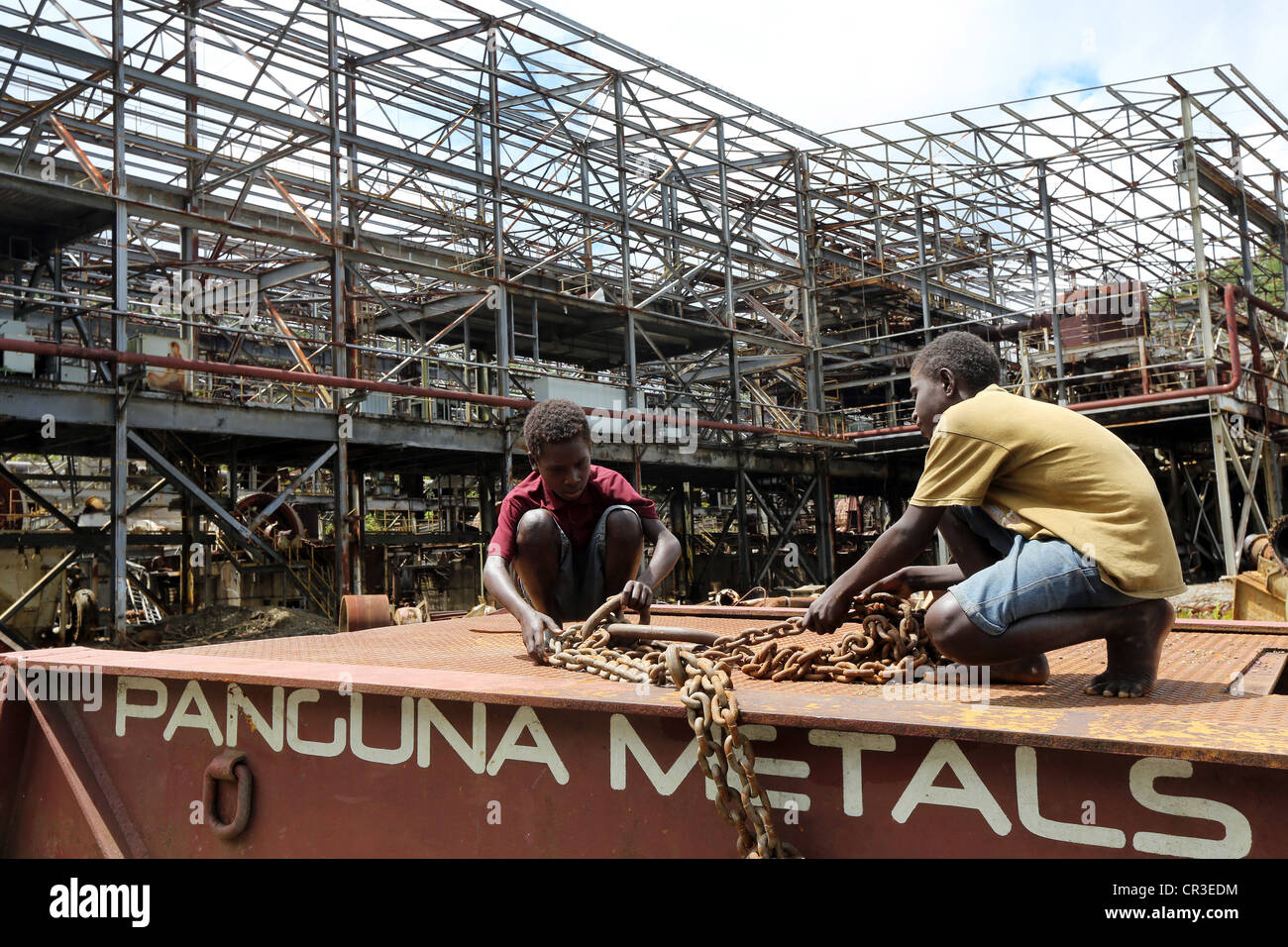 Enfants jouant dans la détruit les installations industrielles dans la mine de cuivre de Panguna. Banque D'Images