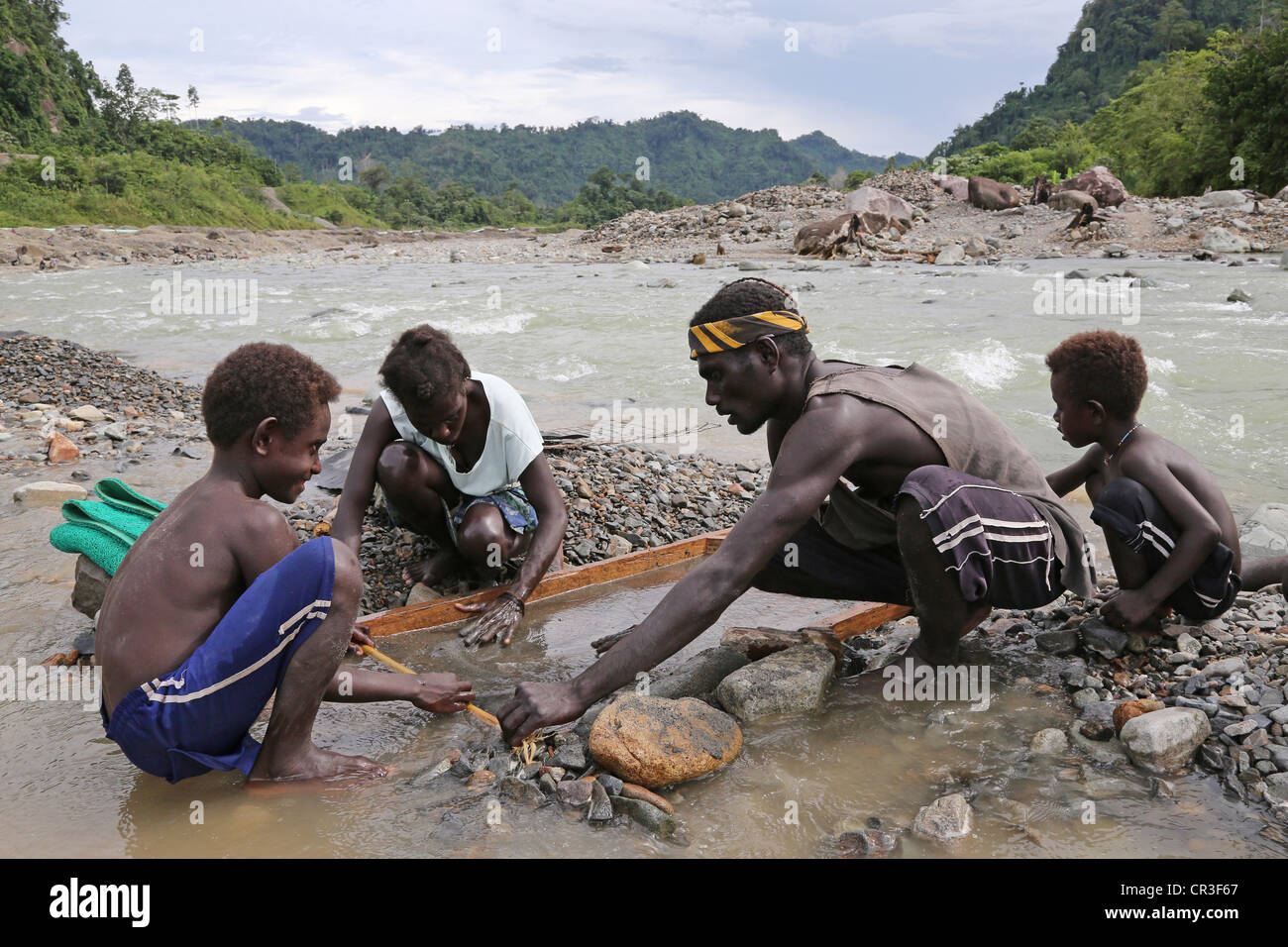 Le panoramique de la famille d'or dans la rivière polluée Jaba découlant de la mine de cuivre de Panguna. La région autonome de Bougainville, PNG Banque D'Images