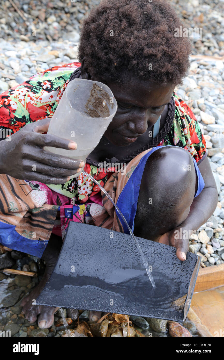 Or dans la batée femme Jaba polluée rivière qui coule à partir de la mine de cuivre de Panguna. La région autonome de Bougainville, PNG Banque D'Images