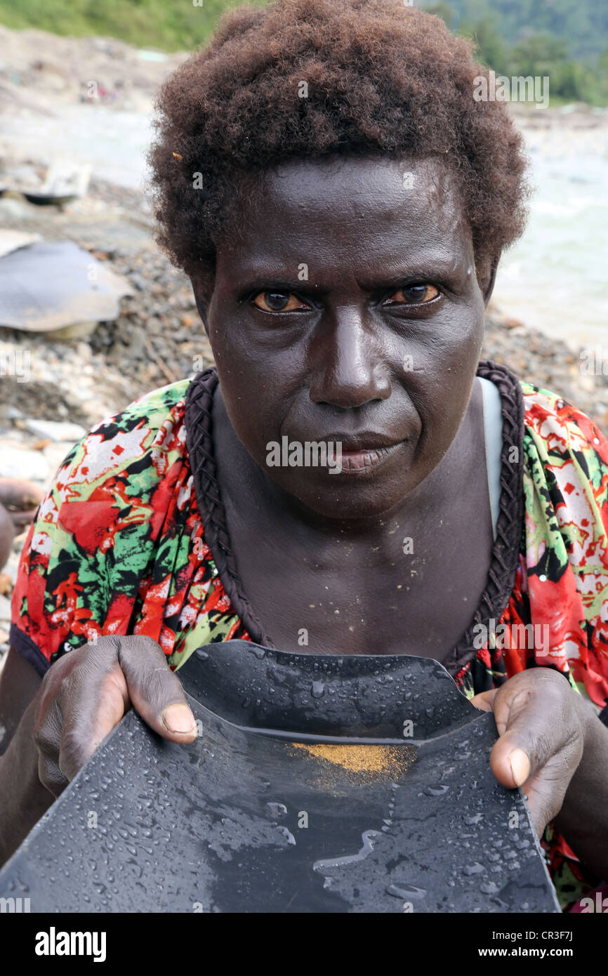 Or dans la batée femme Jaba polluée rivière qui coule à partir de la mine de cuivre de Panguna. La région autonome de Bougainville, PNG Banque D'Images