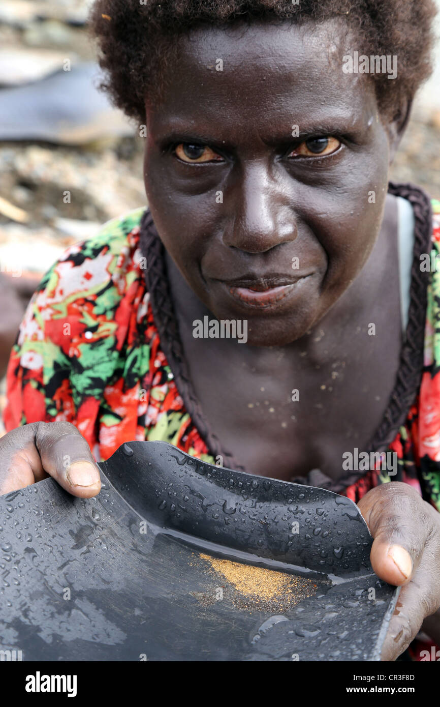 Or dans la batée femme Jaba polluée rivière qui coule à partir de la mine de cuivre de Panguna. La région autonome de Bougainville, PNG Banque D'Images