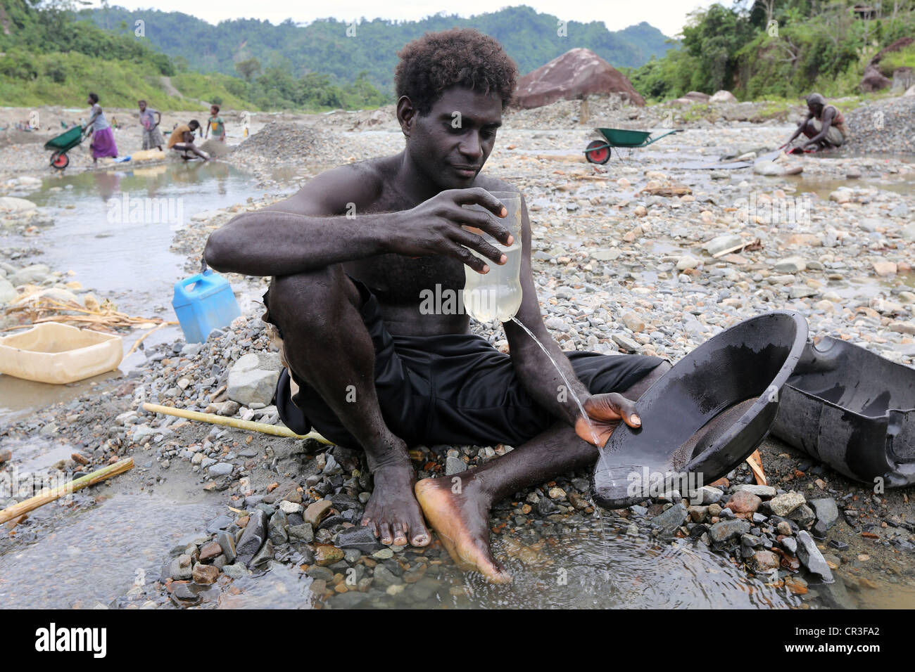 L'homme d'or dans le panoramique de la rivière polluée Jaba découlant de la mine de cuivre de Panguna. La région autonome de Bougainville, PNG Banque D'Images