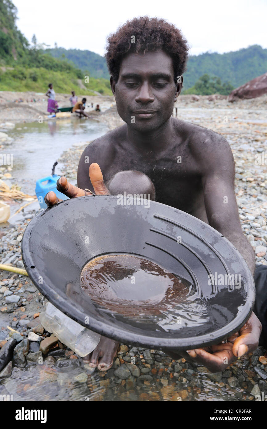 L'homme d'or dans le panoramique de la rivière polluée Jaba découlant de la mine de cuivre de Panguna. La région autonome de Bougainville, PNG Banque D'Images