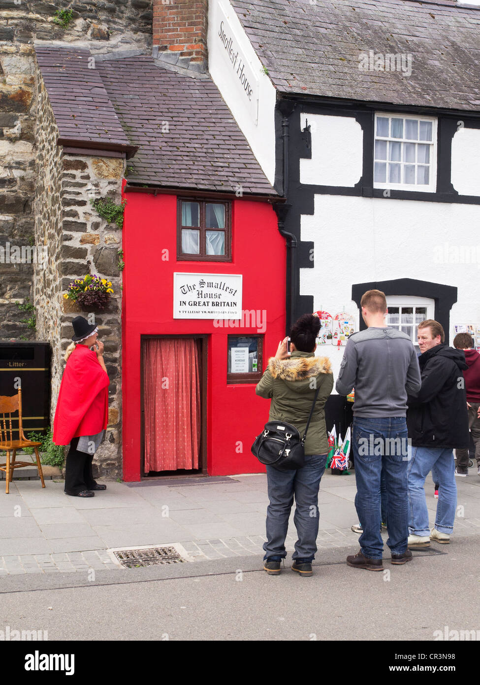 La plus petite maison en Grande-Bretagne à Conwy dans le Nord du Pays de Galles avec une femme keeper en gallois et les touristes prenant des photos robe Banque D'Images
