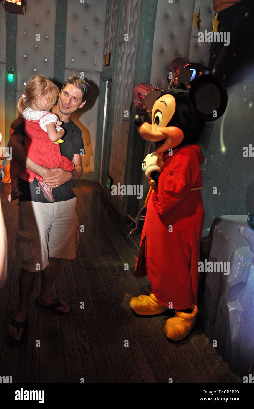 La souris de Mickey accueille une petite fille timide étant détenu par son père à Mickey's House Studio à Disneyland, Anaheim, Californie Banque D'Images