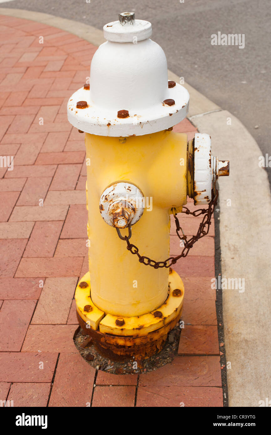 Vieux poteau incendie jaune sur le trottoir Banque D'Images