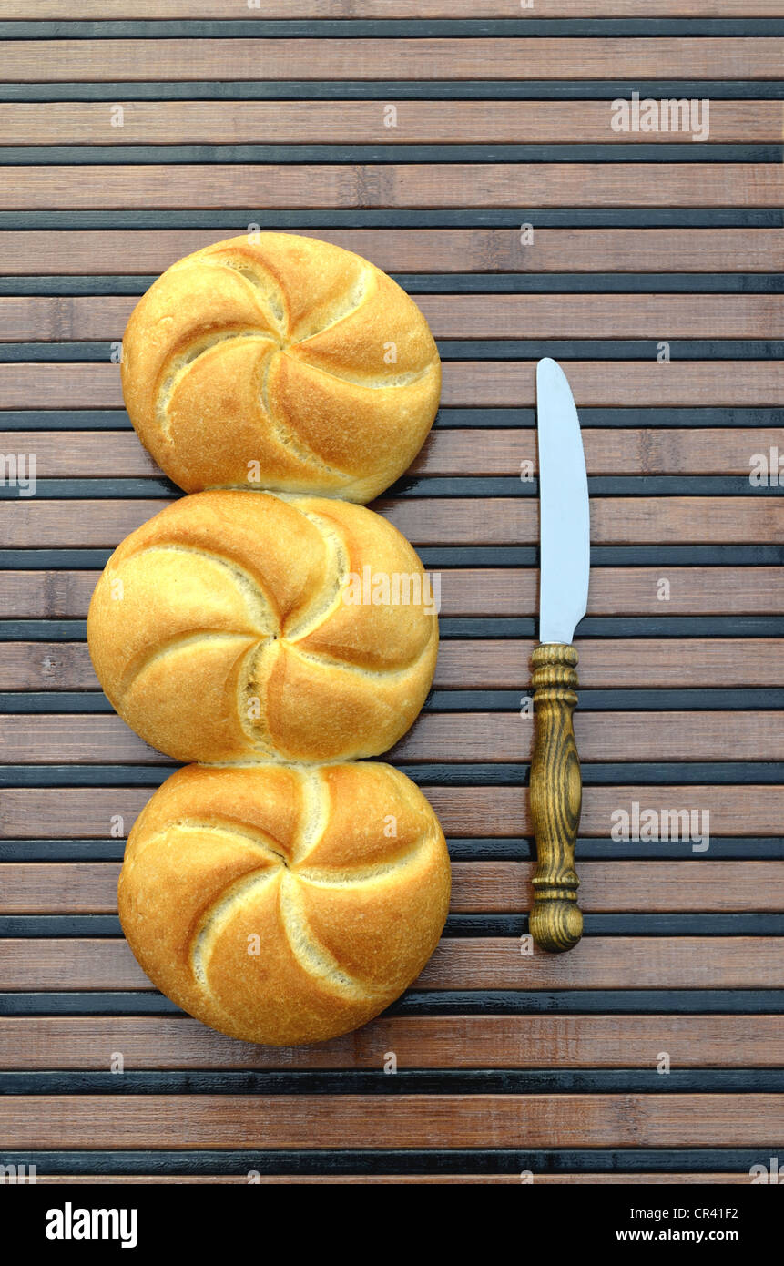 Trois petits pains attenant à côté d'un petit-déjeuner couteau avec un manche en bois Banque D'Images