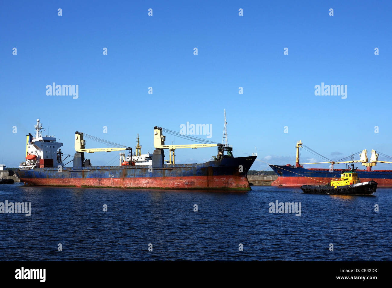 Le tow fait glisser le cargoship à Harbour Banque D'Images