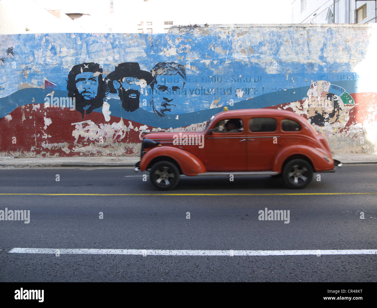 American Vintage voiture roulant le long d'un mur avec des peintures de Fidel Castro et Che Guevara, La Havane, Cuba, Amérique Latine Banque D'Images