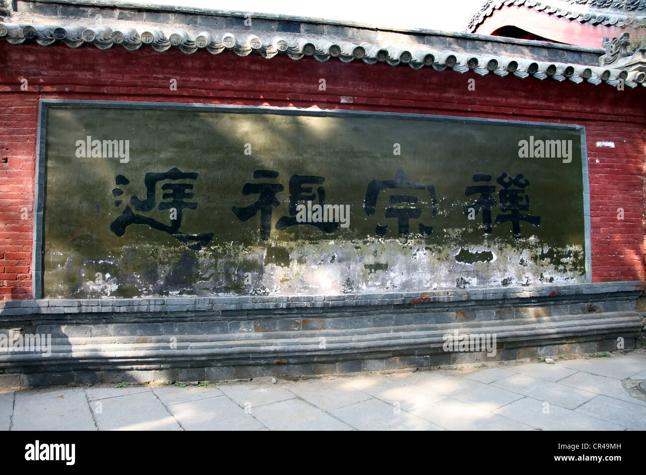 C'est une photo de l'entrée du mur d'un temple en Chine. Il a signe ou symbole chinois ou le caractère peint sur les briques rouges. Banque D'Images