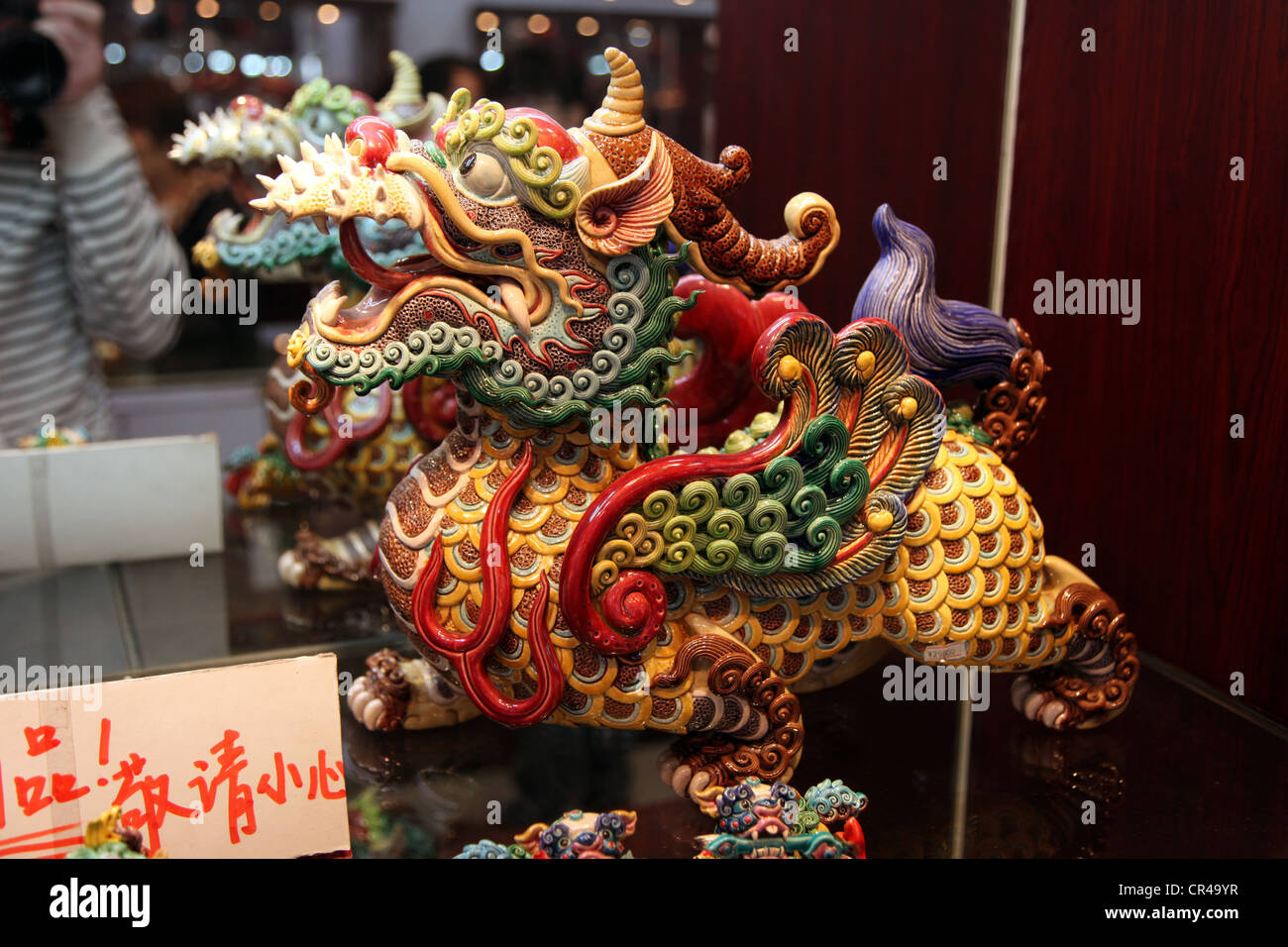 C'est une petite statue d'un Dragon chinois dans un magasin sur une tablette de la Chine. C'est une poterie artisanale très coloré. Symbole de la Chine Banque D'Images