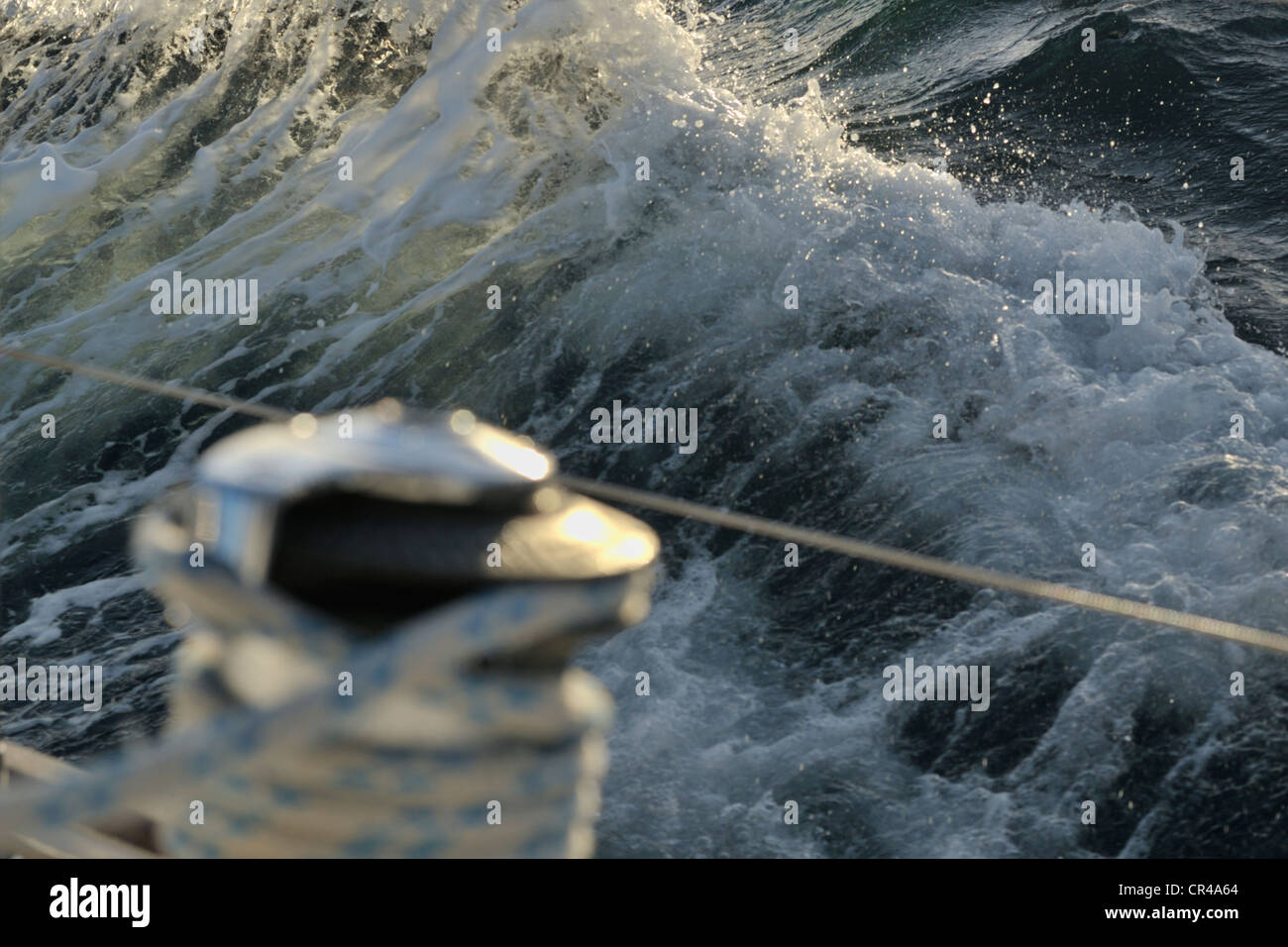 Les vagues déferlantes a vu au le treuil d'un yacht de croisière à l'aube de l'ouest, la mer des Caraïbes. Les mers sont des capacités de l'avant d'un coup de vent. Banque D'Images