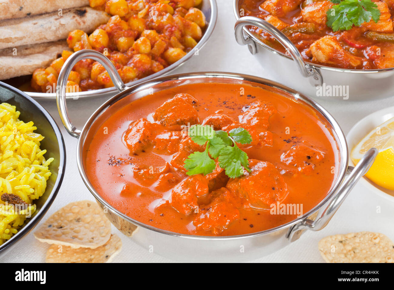 Sélection de plats au curry avec riz pillau, rogan josh, chana dhal, poulet jalfrezi et poppadums. Banque D'Images