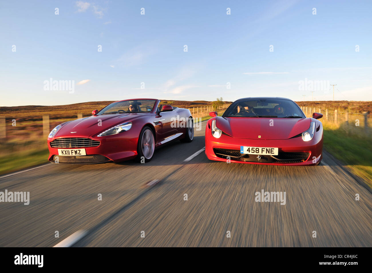 Ferrari 458 Italia et Aston Martin Virage route côte à côte au coucher du soleil Banque D'Images