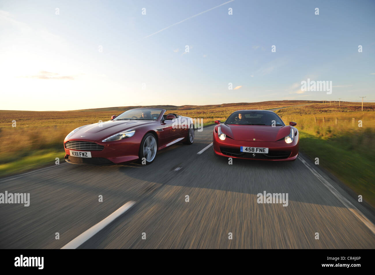 Ferrari 458 Italia et Aston Martin Virage route côte à côte au coucher du soleil Banque D'Images